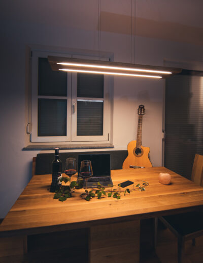 Lichten Lampe aus Eichenholz in abgehängter Variante über einem Esstisch